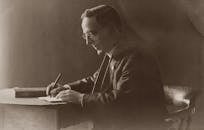 Old Photo Of Man In Black Suit Writing on Notebook