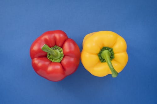 Free Red and Yellow Peppers on Blue Background Stock Photo