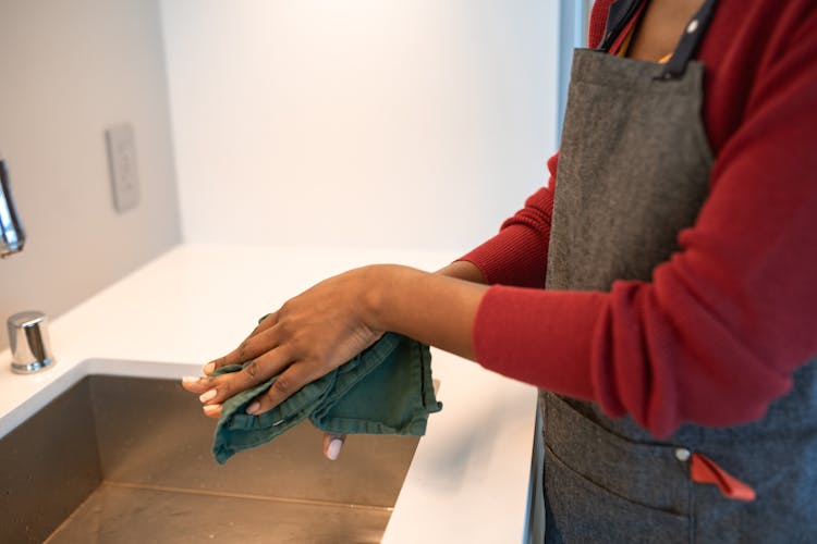 A Person In An Apron Wiping Their Hands