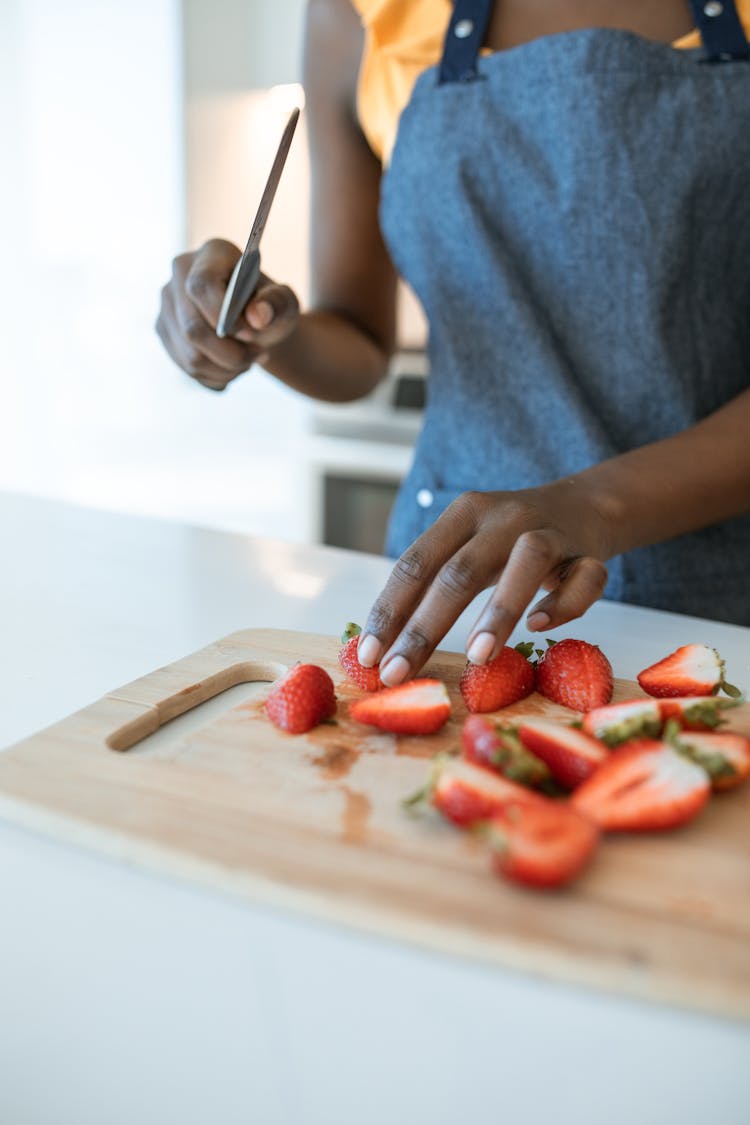 A Person Slicing Strawberries