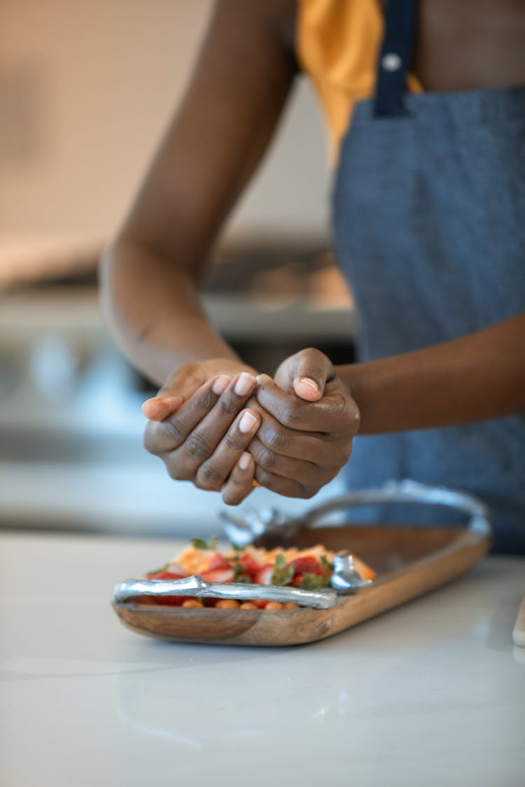 Person Putting Food On Wooden Tray