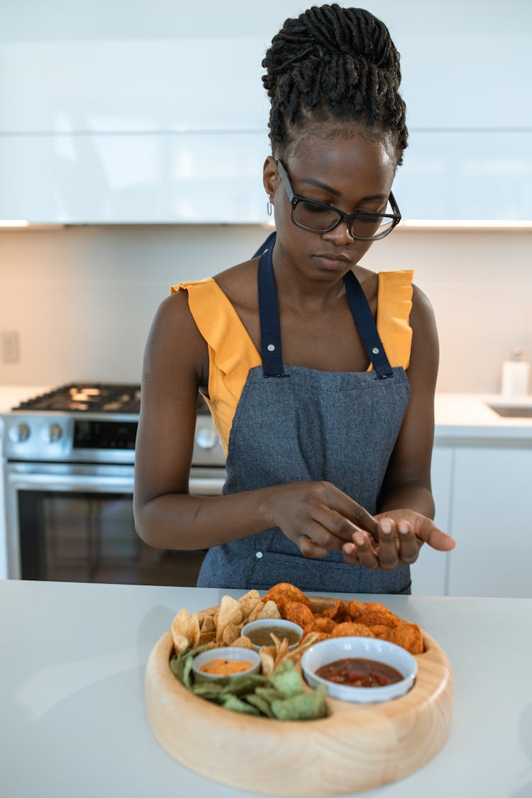 Woman In Blue Apron Preparing A Food Platter