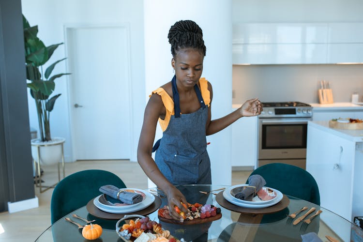 Woman Wearing A Blue Apron Preparing Food