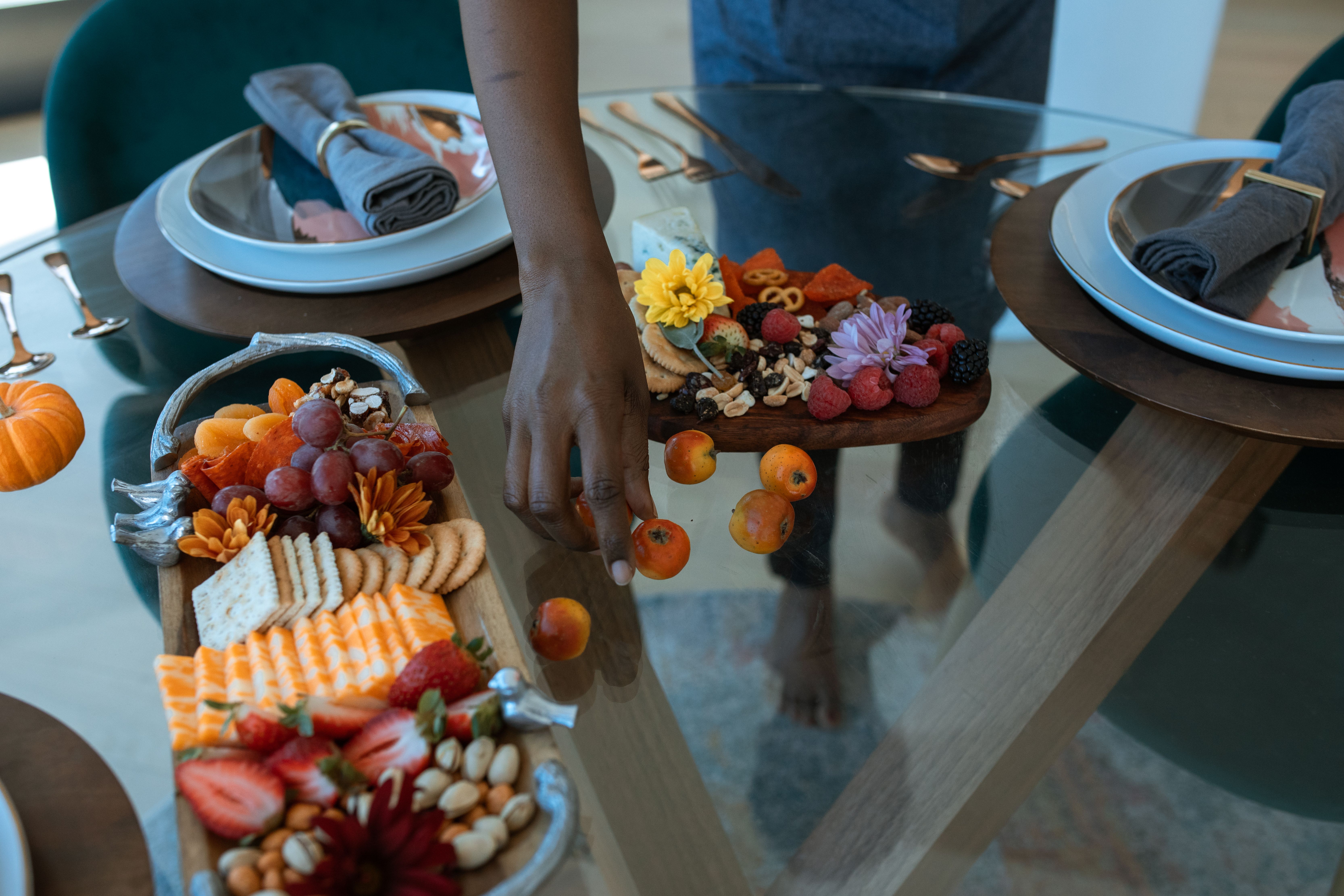 A large wooden board filled with an assortment of fruits, nuts, bread, and dips for a holiday gathering
