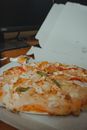 Delicious pizza in takeaway box on table