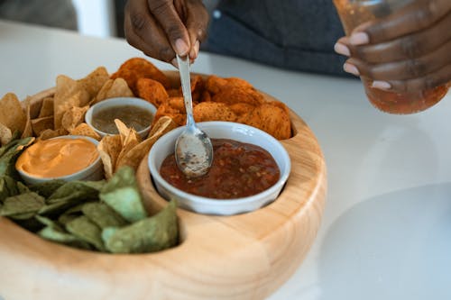 Kahverengi Soslu Gümüş Kaşık Tutan Kişi