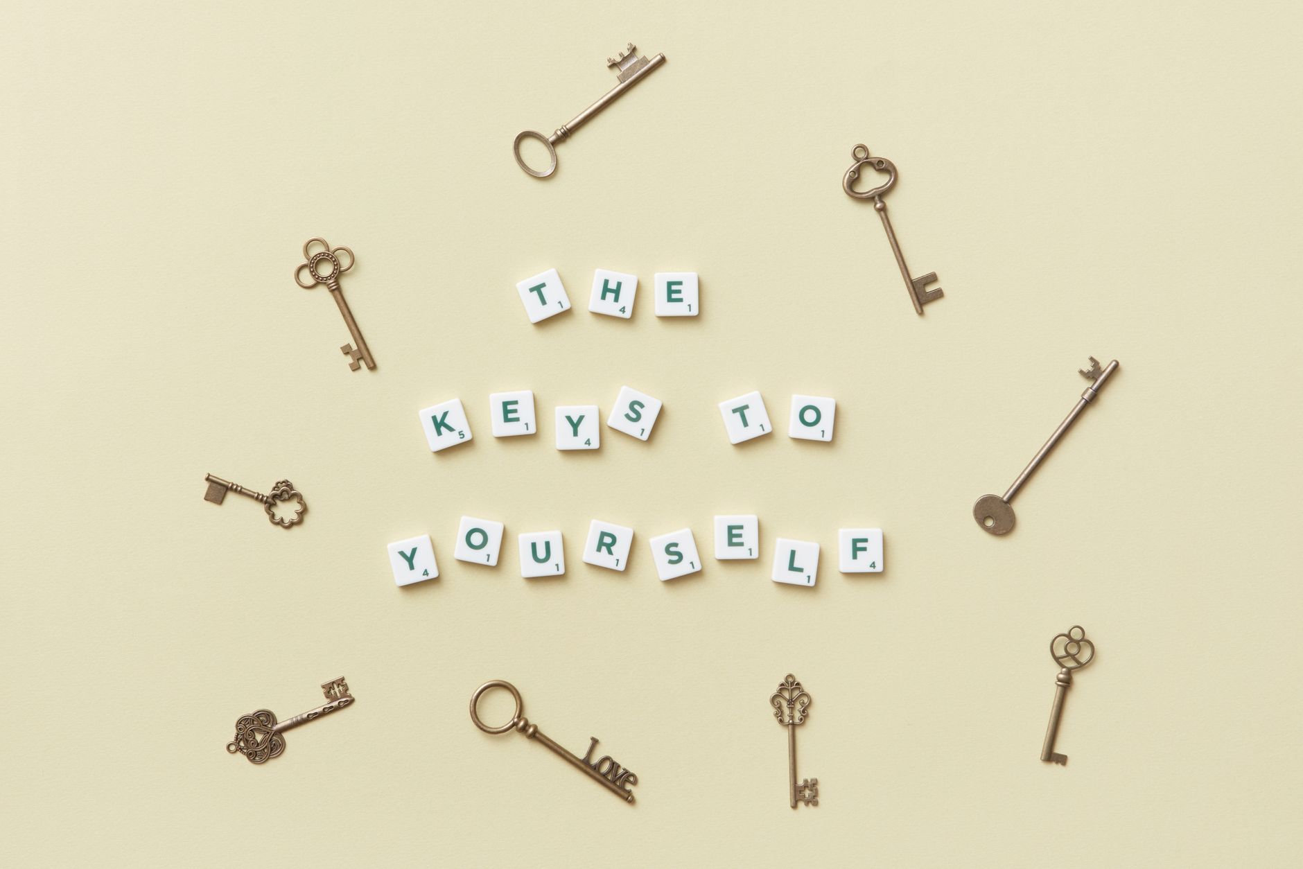 Motivational message with antique keys and letter blocks on yellow background.