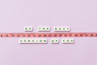Motivational phrase 'Be the Best Version of You' with a measuring tape on purple background.