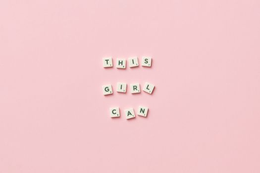 Scrabble tiles spelling 'This Girl Can' on a pink background.