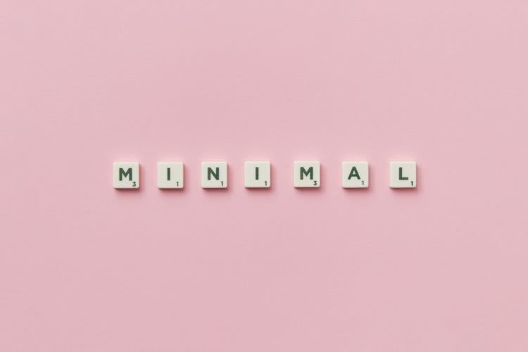 Scrabble Letters Arranged To Spell The Word Minimal On Pink Background