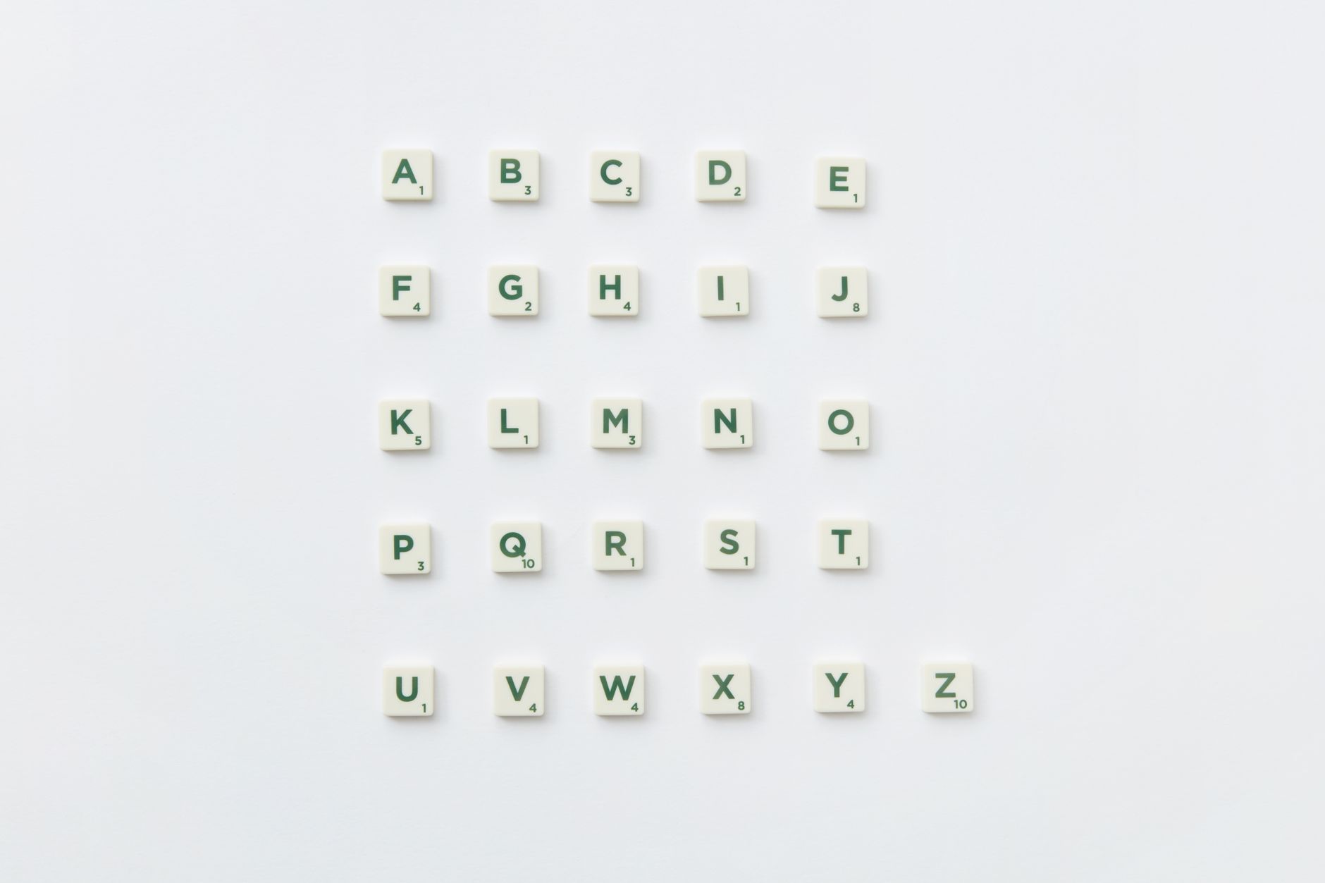 Scrabble letter tiles arranged into the alphabet on a white background.