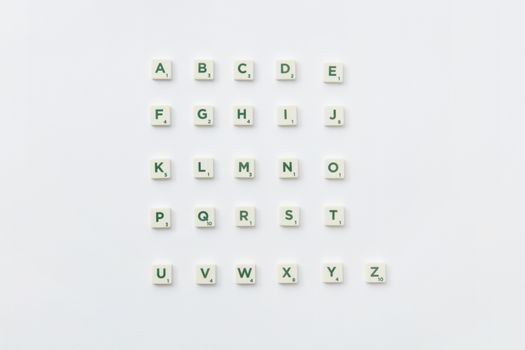Scrabble letter tiles arranged into the alphabet on a white background.