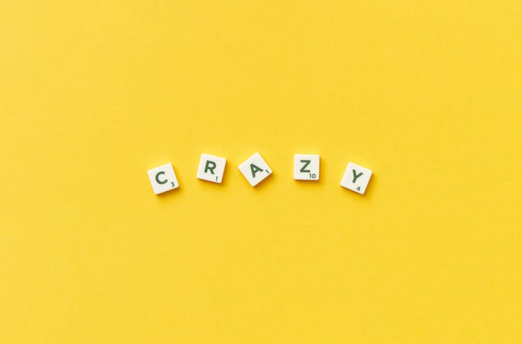 Crazy Spelled In Scrabble Letters On Yellow Background