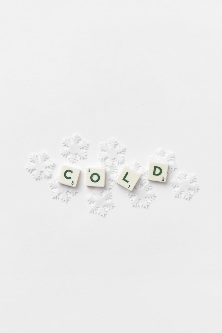 Snowflakes Under Scrabble Letters Spelling Out The Word Cold