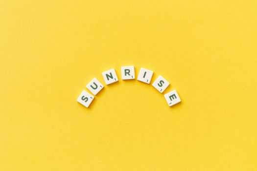 Abstract Description of Sunrise by Scrabble Tiles on Yellow Background