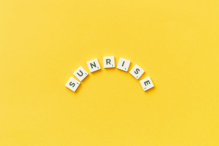 Abstract Description Of Sunrise By Scrabble Tiles On Yellow Background