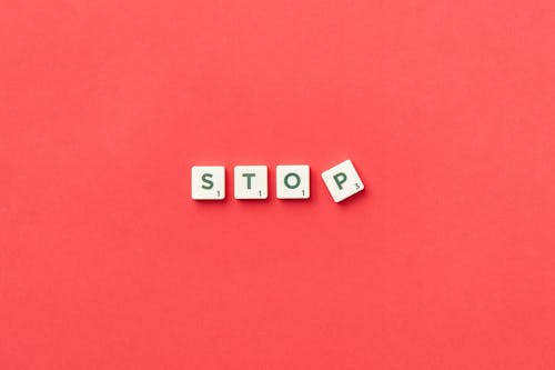 White Scrabble Pieces with Green Letters on Red Surface