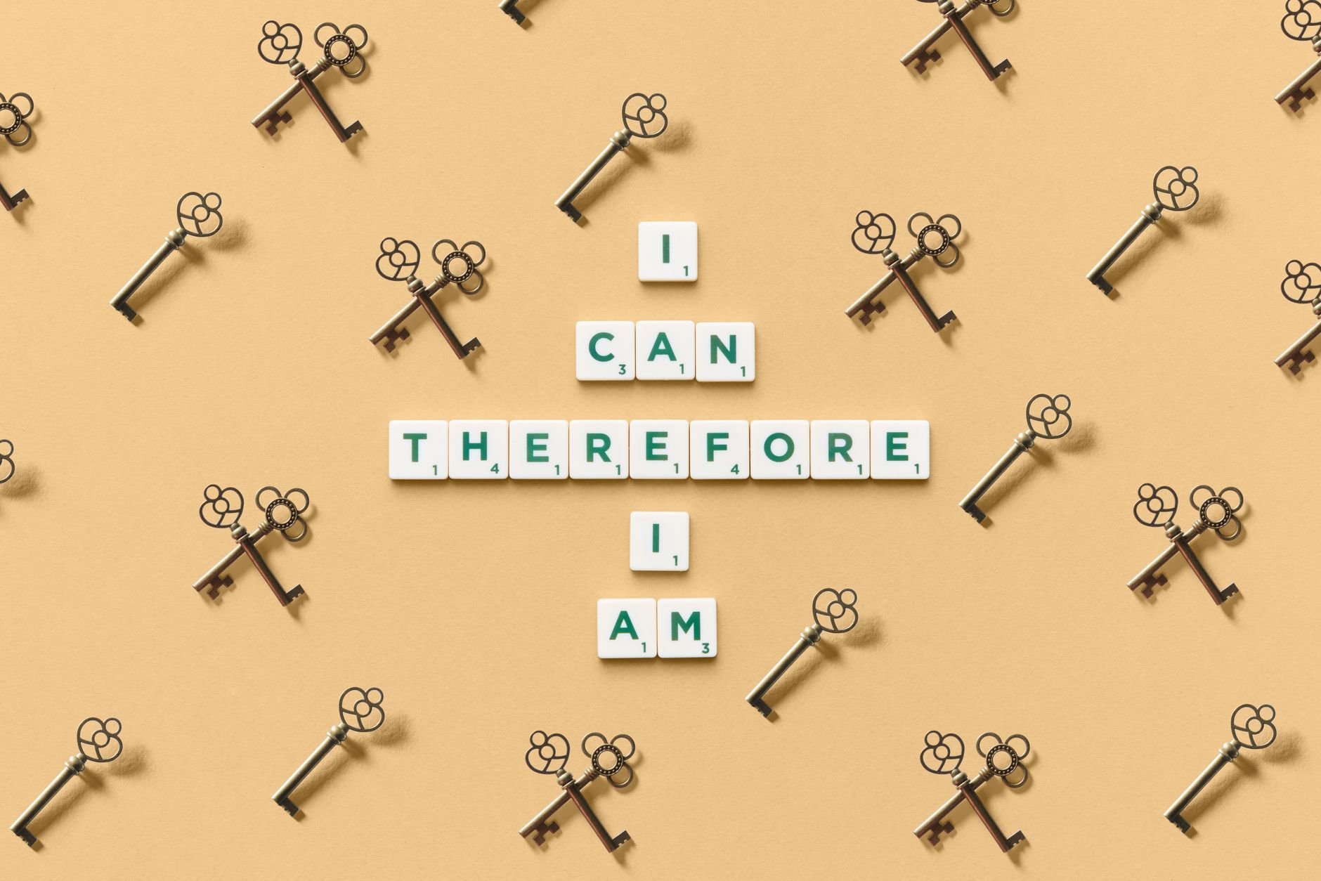 Inspirational phrase made from tiles surrounded by decorative keys on a beige background.