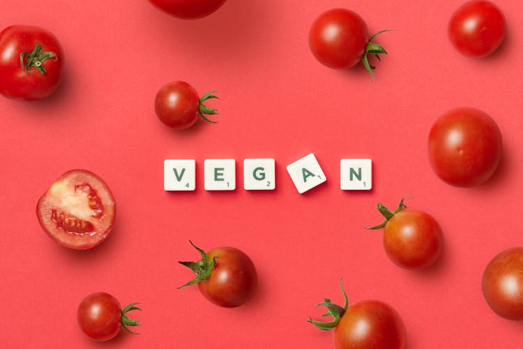 Letters Spelling The Word Vegan And Tomatoes Around Them