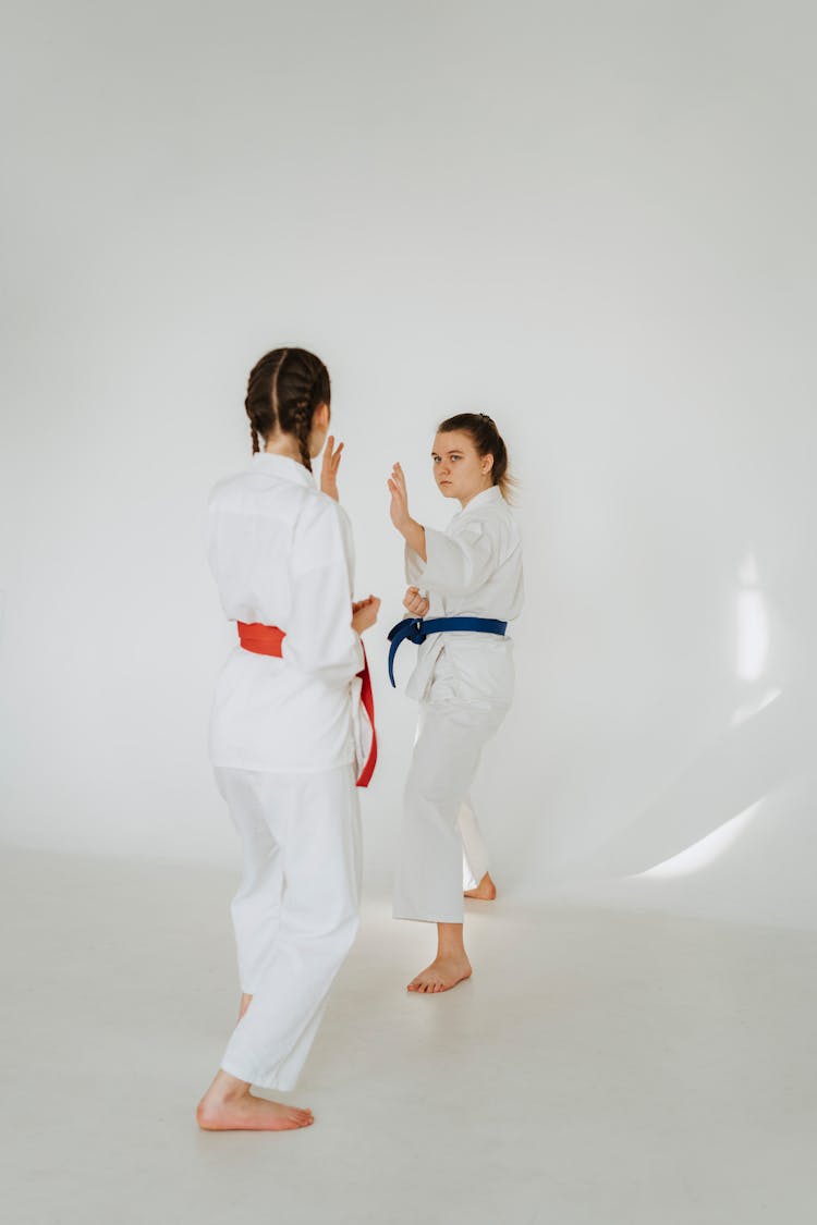 Girls Performing Martial Arts In White Clothes And Colour Belts