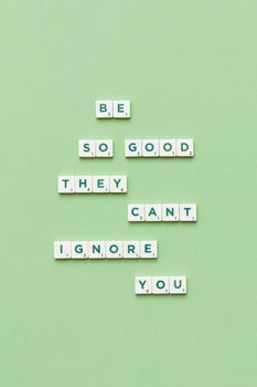Scrabble tiles forming 'Be so good they can't ignore you' on a pastel green background.