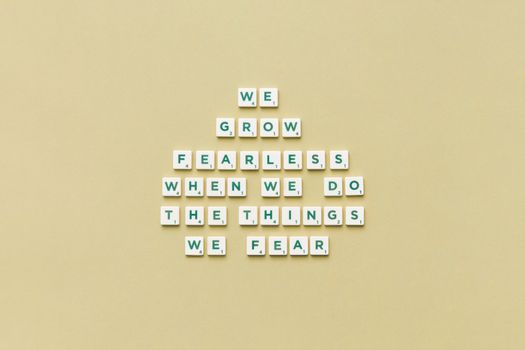 Scrabble pieces arranged to form a motivational quote on a plain background.