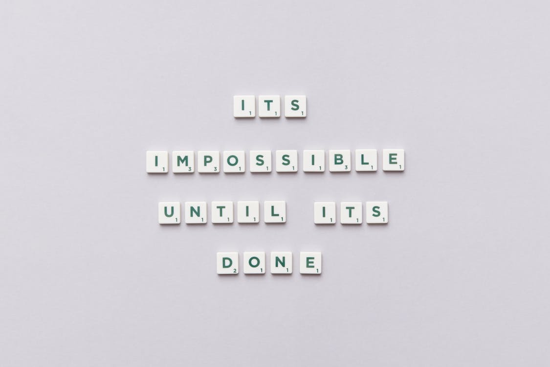 A Phrase Spelled with Scrabble Tiles on a White Background