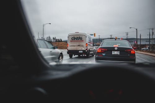 Vehicles driving on highway against cloudy sky