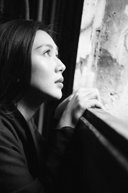 Free Side view black and white of young Asian woman touching window with hands while looking away thoughtfully Stock Photo