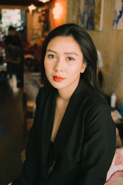 Free Serious young Asian woman wearing elegant black jacket looking at camera while sitting in cozy room Stock Photo