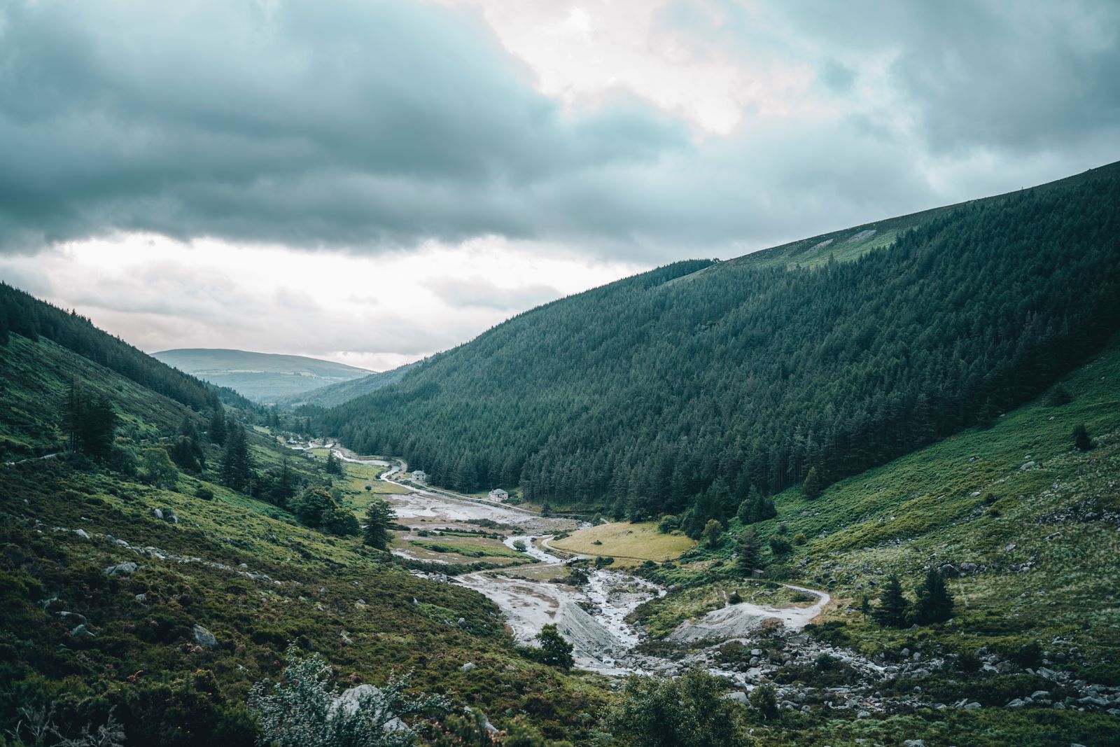 View of a valley and river in Wicklow, Ireland, under cloudy skies