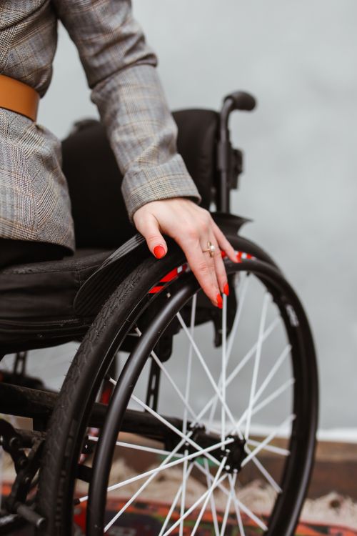 Free Close-up view of a woman's hand resting on a wheelchair wheel, showcasing independence and empowerment. Stock Photo