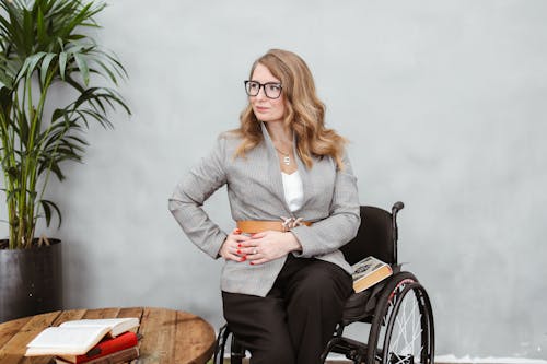 Free Woman in Gray Blazer Sitting on Brown Wooden Chair Stock Photo