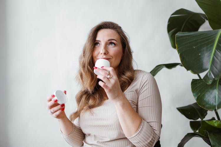 Woman Smelling A Facial Cream