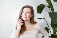Woman in Beige Long Sleeve Shirt Holding a Jade Roller