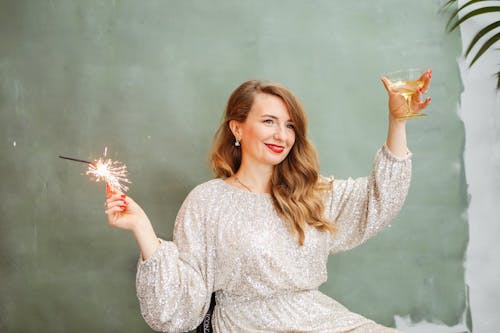 Free Woman Holding a Glass of Wine and Sparkler Stock Photo