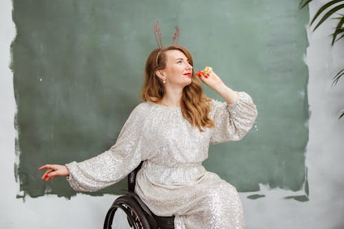 Woman Wearing Reindeer Headband Holding a Party Blower