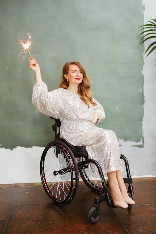 Free Girl in White Long Sleeve Shirt Sitting on Black Wheelchair Stock Photo