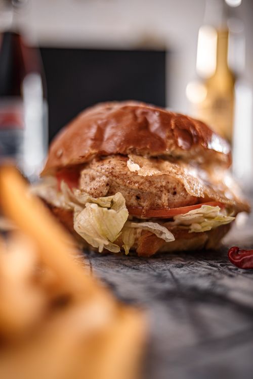 Free Delicious appetizing beef burger with lettuce placed on gray table in fast food restaurant Stock Photo