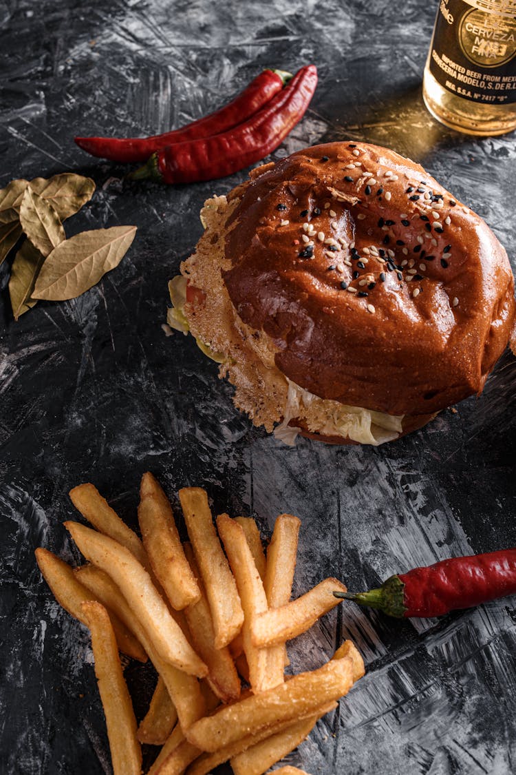 Composition Of Delicious Burger And French Fries On Gray Table