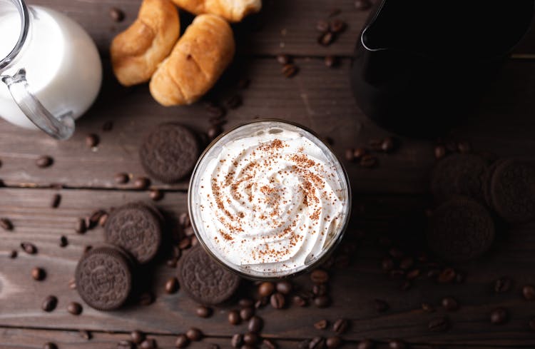 Whipped Cream Drink On Table Amidst Coffee Beans And Cookies