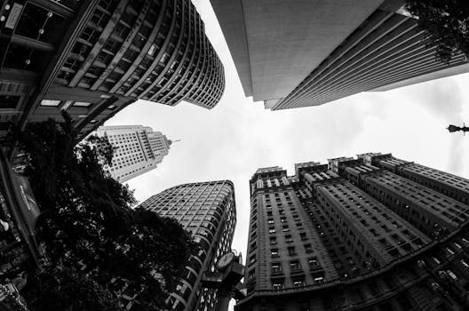 这张引人注目的黑白照片从下方俯瞰着城市景观中高耸的摩天大楼