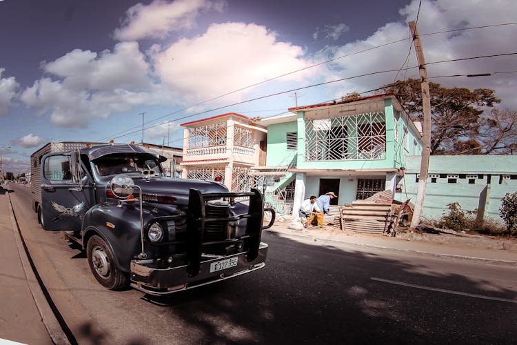 Old Truck On Urban Road With Anonymous Ethnic Citizens