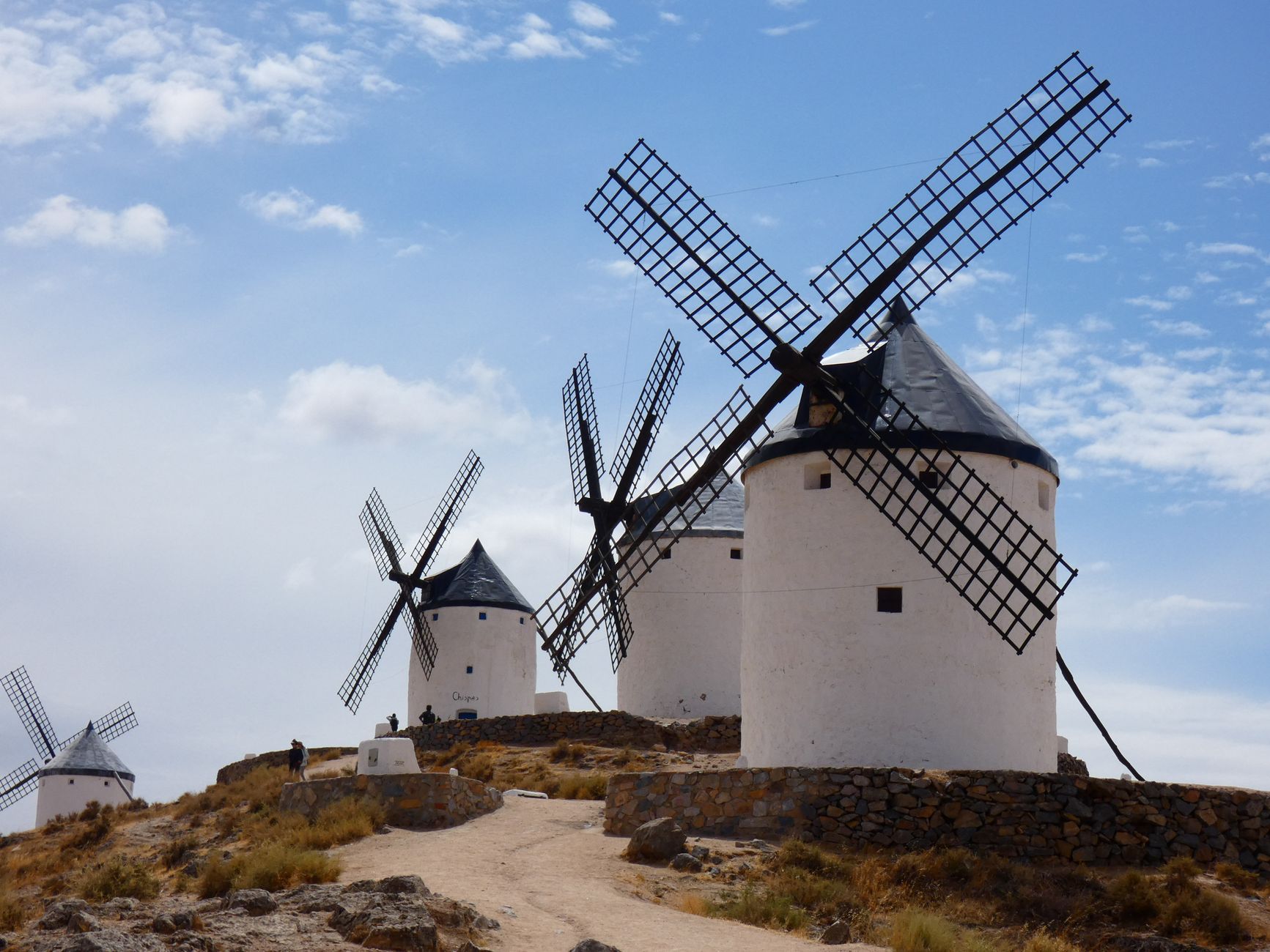 Molinos de viento encalados en fila en lo alto de un cerro manchego