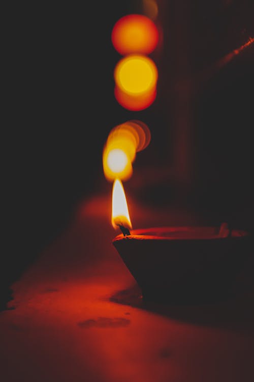 Free Small decorative diya candle placed on surface in darkness for Indian religious festival Stock Photo