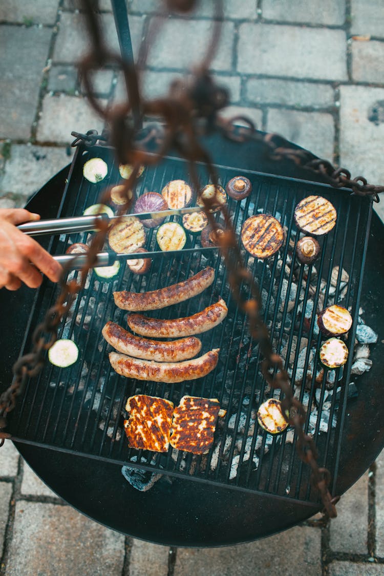 A Person Grilling Food On A Cast Iron Grill