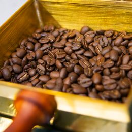 Roasted coffee beans in a gilded tray, photo by Jimmy Ramírez on Pexels