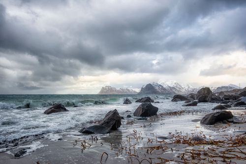 Free Moody seascape featuring rocky coast and overcast sky capturing nature's drama. Stock Photo
