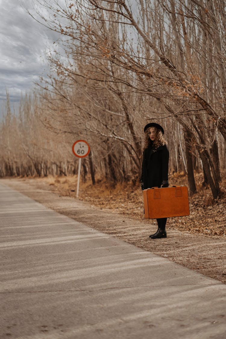 Woman With Vintage Suitcase Near Asphalt Road