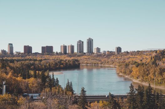 Breathtaking cityscape with a river and fall foliage, perfect autumn travel destination.